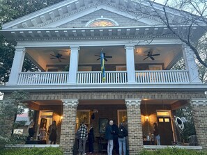A two-story building with a balcony and a covered porch area.