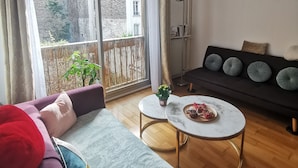 Una sala de estar moderna con un sofá, una mesa de centro y vistas a un balcón.