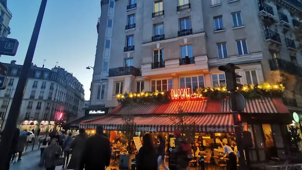 Un edificio de varios pisos con un llamativo letrero de 'DUPONT', que indica la presencia de un negocio o empresa.