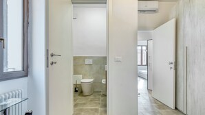 A modern bathroom with a toilet, bidet, and towel rack. - Suite Clapton | BluesHouse Carracci Suites (Bologna)