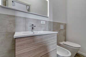 Een douche, een haardroger, een bidet, handdoeken