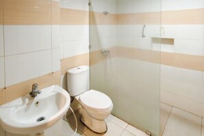Une salle de bain équipée d’un lavabo, de toilettes et d’une douche à parois en verre.