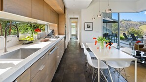 A modern kitchen with a large island, stainless steel appliances, and a view of the outdoors. - Healdsburg Modern Retreat - Pool, Views & Design (Healdsburg)
