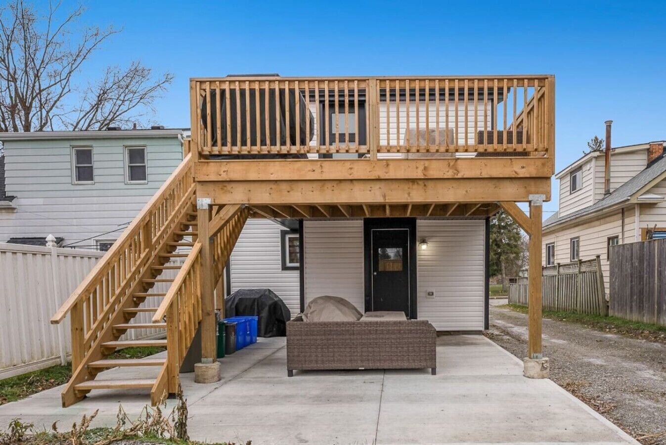 A two-story building with a balcony, a staircase, and a covered outdoor seating area.