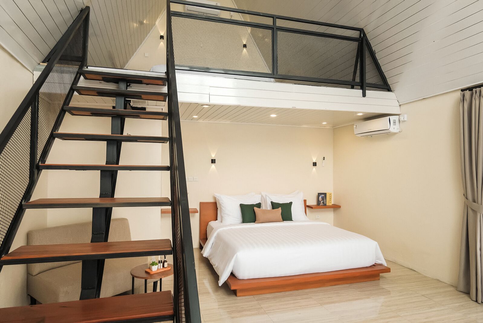 A bedroom with a bunk bed, a wooden staircase, a bedside table, and a small round table with a plant.