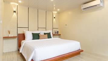 Un dormitorio moderno con cama, mesitas de noche, aire acondicionado de pared y luces empotradas en el techo.
