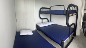 A bunk bed with two levels, a white door, and a small table with a chair. - Rest apartment in Girardot. (Girardot)