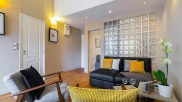 Design Apartment, Balcony, City View | Living area | 55-inch flat-screen TV with digital channels