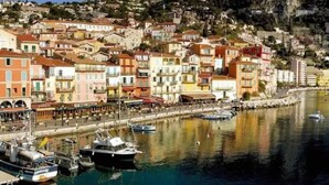 A coastal town with colorful buildings, a marina with boats, and a hillside in the background. - Mediterranean Horizon (Villefranche-sur-Mer)