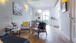 A modern living room with a dining area, wooden flooring, and a large window providing natural light. - Mediterranean Horizon (Villefranche-sur-Mer)