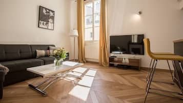 Appartement Deluxe, vue cour intérieure | Coin séjour | TV connectée de 55 pouces avec chaßnes numériques, Netflix