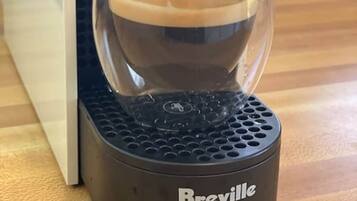 Une machine à café Breville avec une tasse en verre sur le dessus.