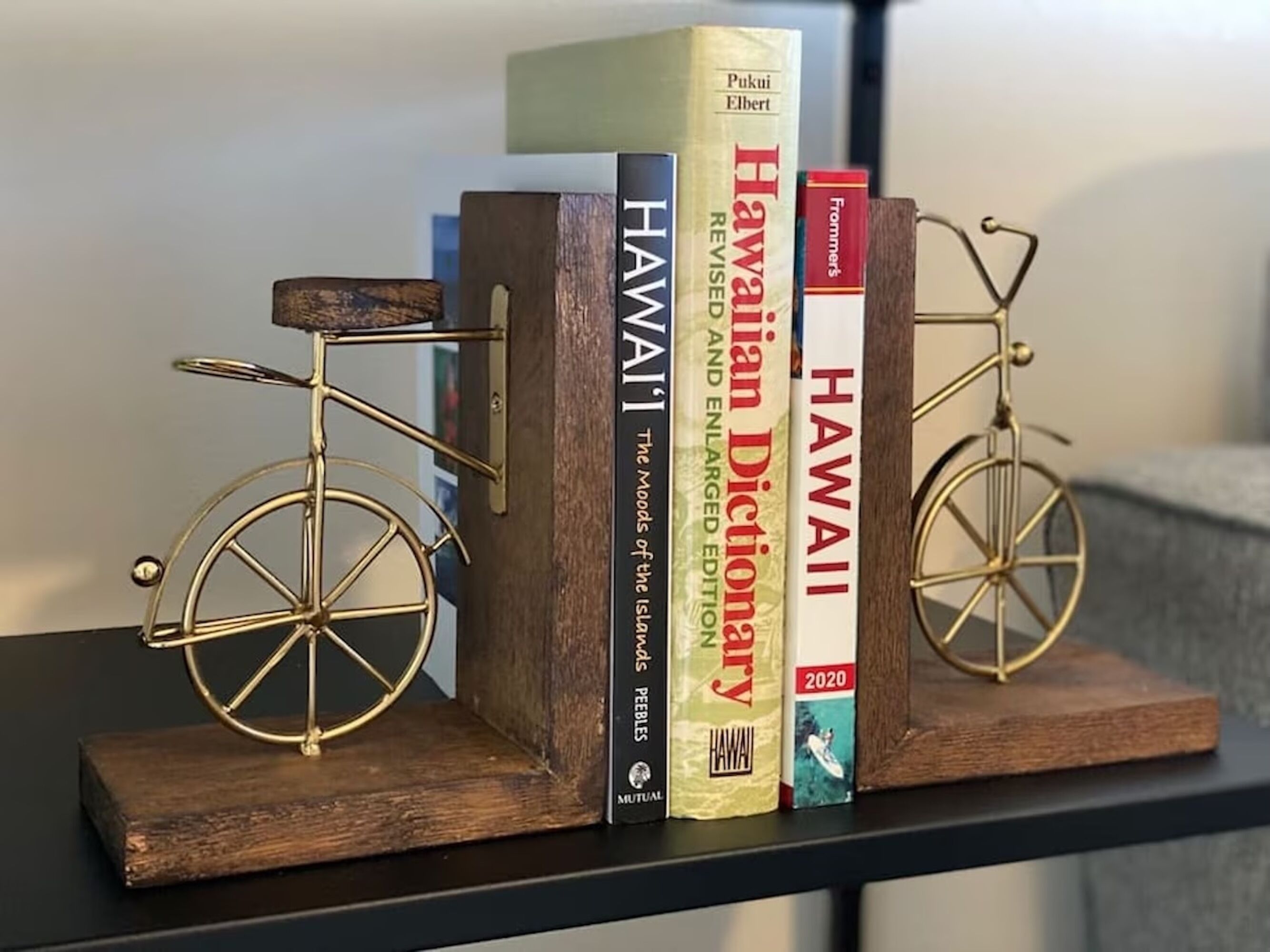 A bookshelf with books and two decorative bicycles.