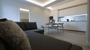 Una sala de estar moderna con un sofá y un comedor con mesa y sillas.