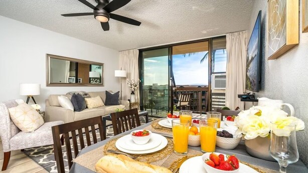 Un coin repas avec une table mise pour le petit-déjeuner, comprenant du pain, des fruits et du jus d’orange.