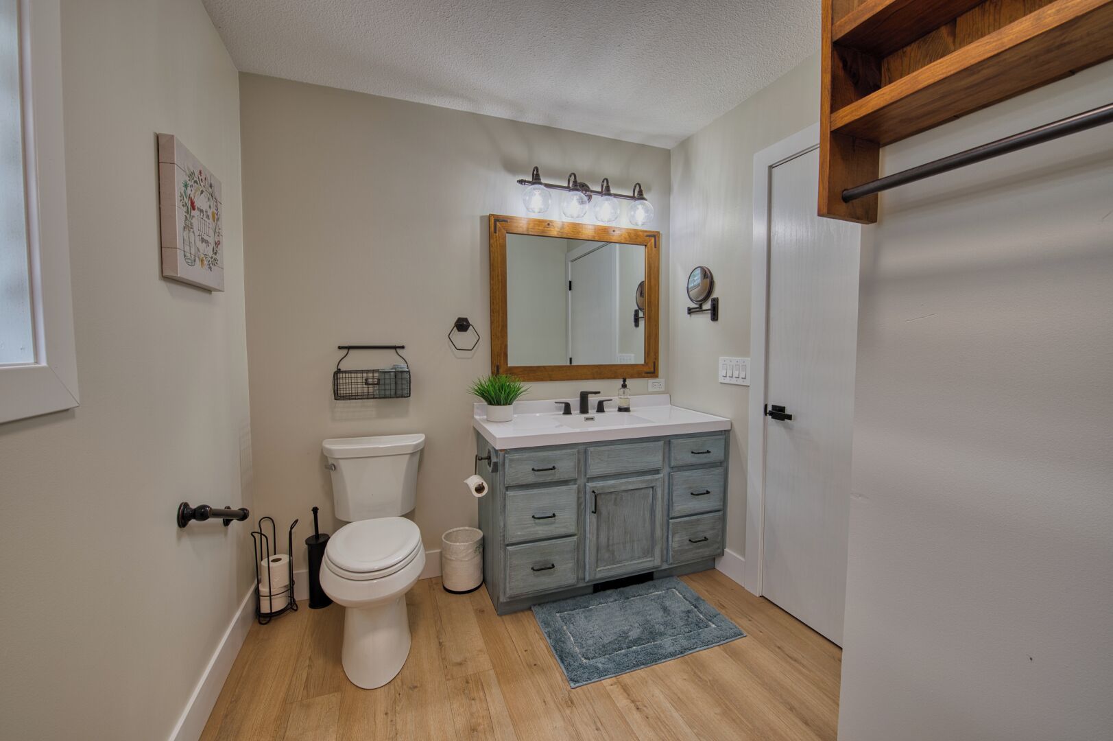 A bathroom with a toilet, sink, and vanity.