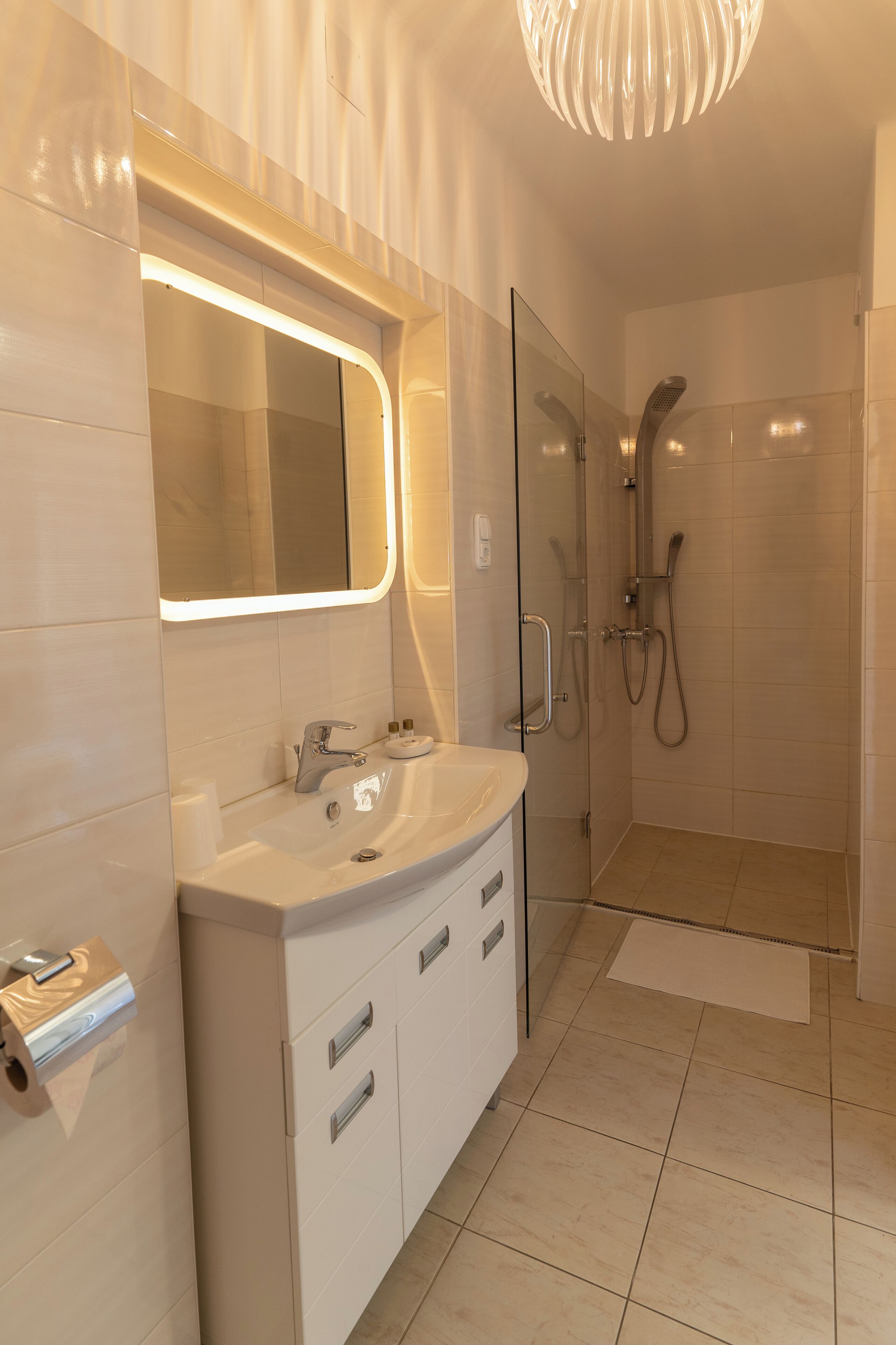 A modern bathroom with a glass shower enclosure, a vanity with a mirror, and a toilet.
