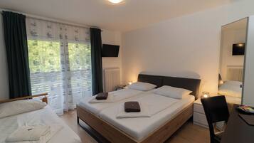 A modern hotel room with a wooden bed, a desk, and a chair.