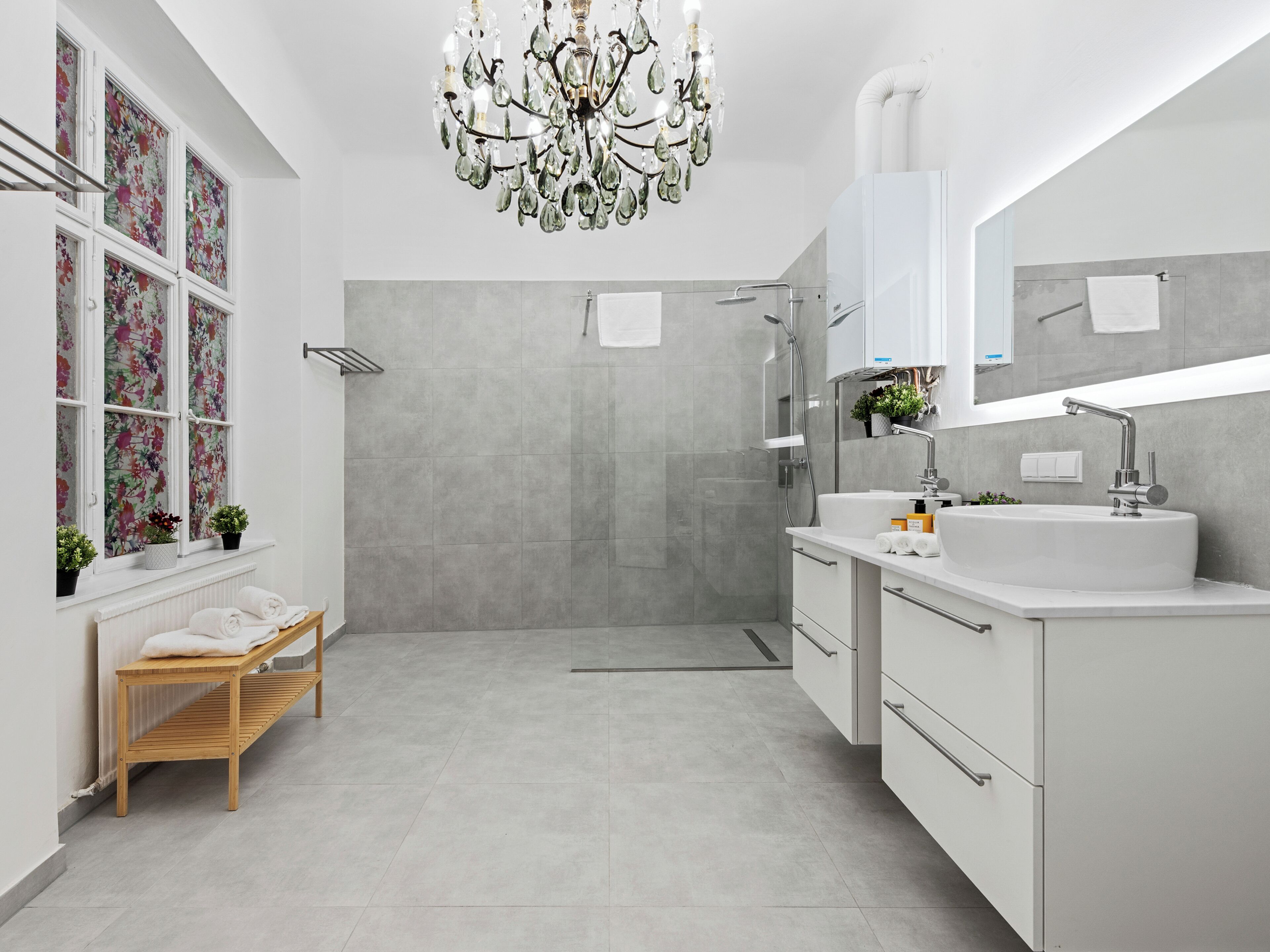 Une salle de bain moderne avec une douche, un lavabo et un grand miroir.