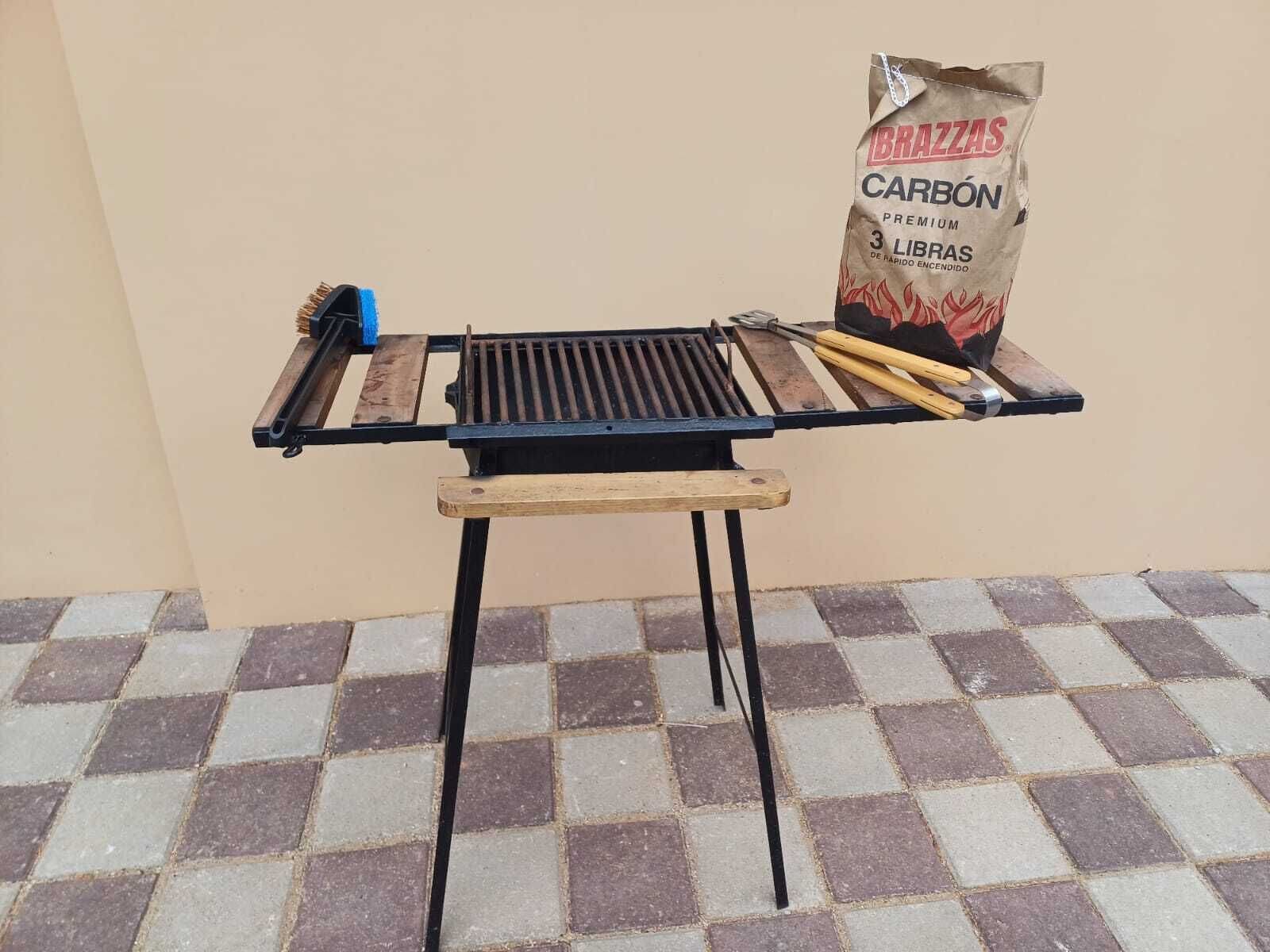 A barbecue grill with a bag of charcoal and grilling tools.