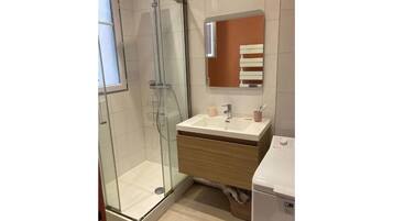 Een douche, handdoeken, toiletpapier