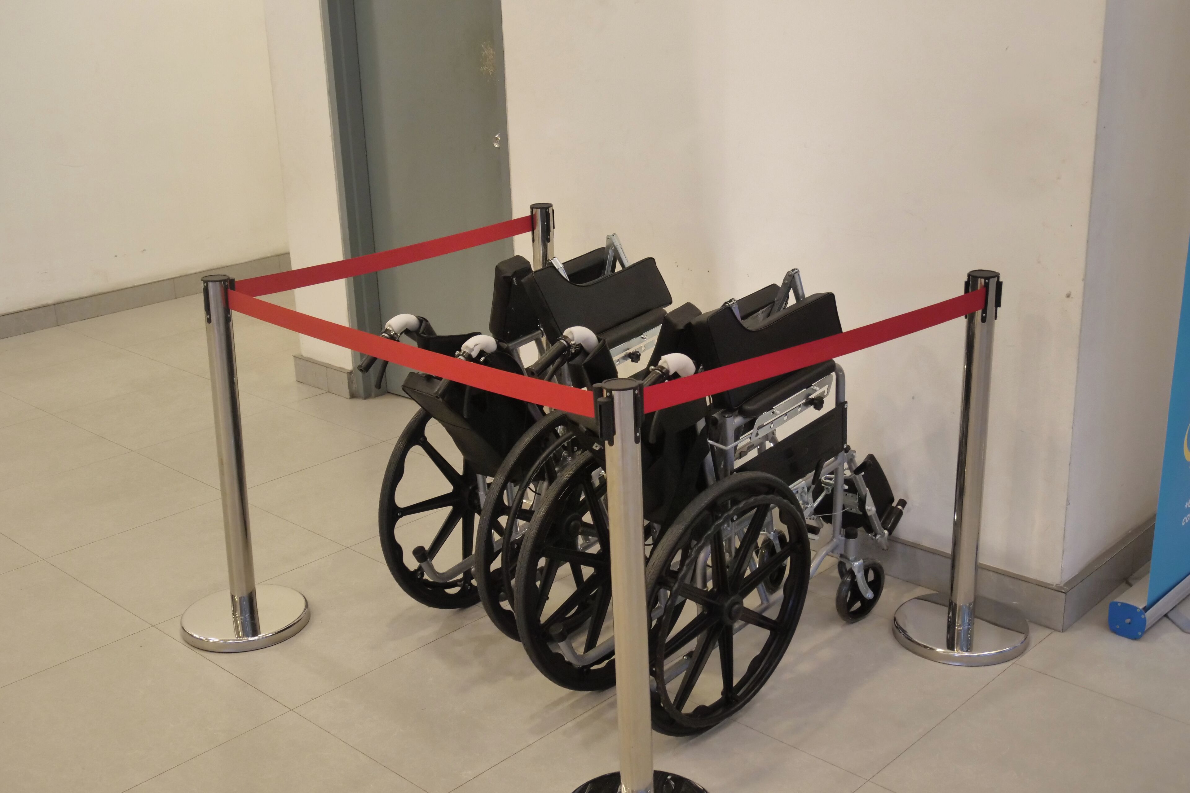 A wheelchair accessible area with a red rope barrier and a wheelchair.