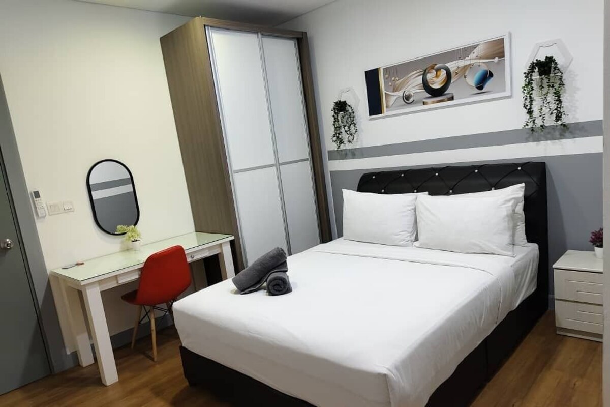 Een slaapkamer met een bed, een bureau, een stoel, een spiegel en een kunstwerk aan de muur.