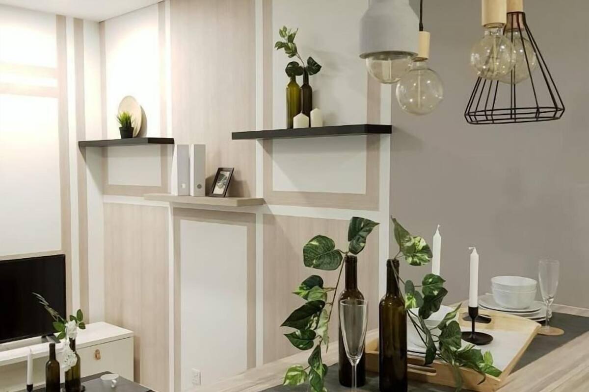 Une cuisine moderne dotée d’un îlot central en bois, de luminaires suspendus et d’un téléviseur encastré.