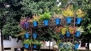 A garden with a wooden structure holding potted plants and two statues. - Loft Flor de Azahar with FREE PRIVATE PARKING (Córdoba)