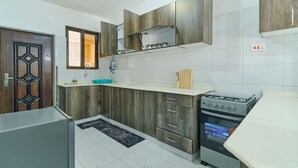 Eine Küche mit Holzschränken, einem eingebauten Ofen und einem Kühlschrank.