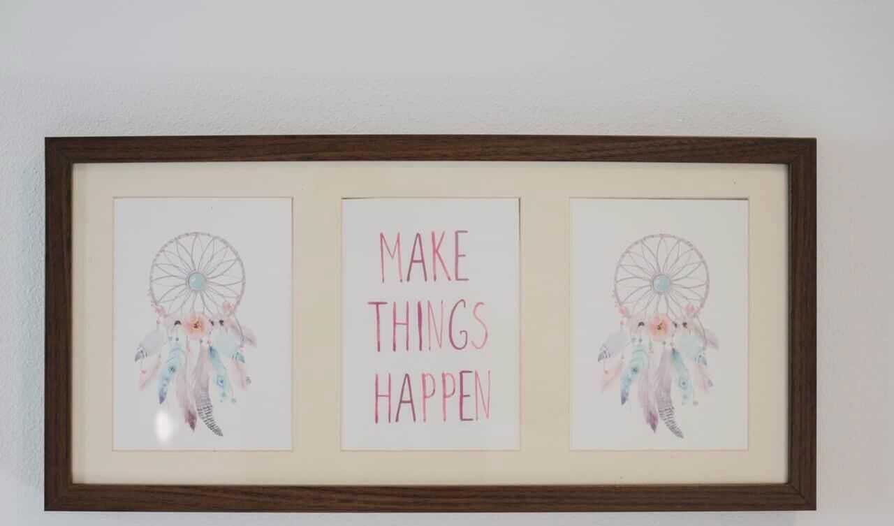 Une œuvre d’art encadrée, comprenant deux attrape-rêves et une citation inspirante.