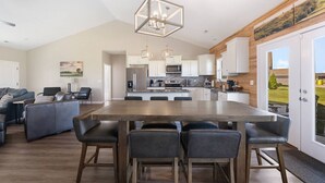 A modern kitchen with a large island, white cabinets, and stainless steel appliances.