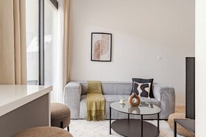 A modern living room with a grey sofa, a round coffee table, and a minimalist decor.