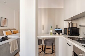 A modern kitchen with a built-in microwave, coffee maker, and wine bottle.
