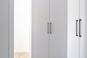 A white wardrobe with two doors and a handle.