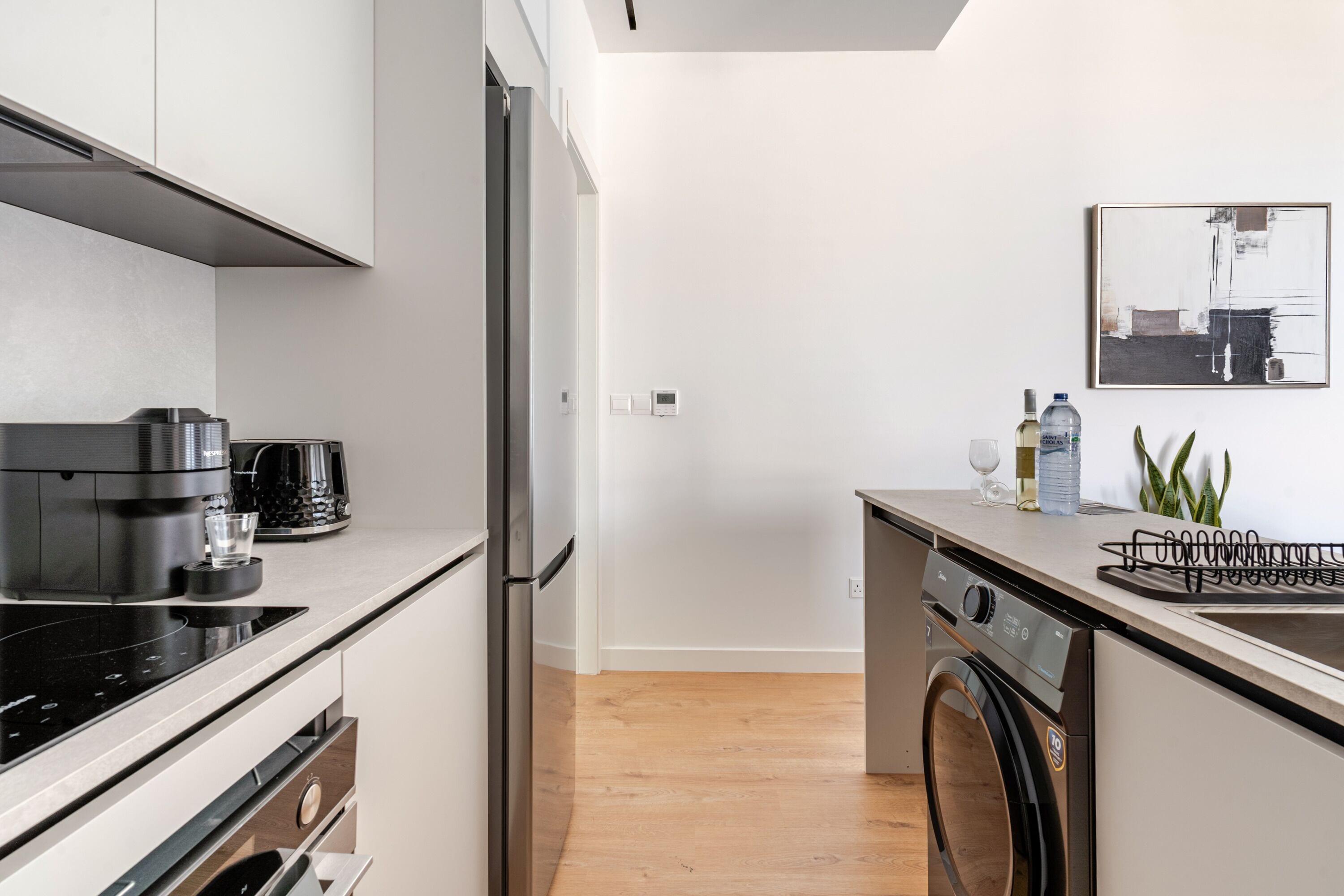 A modern kitchen with a built-in oven, a coffee maker, and a dishwasher.