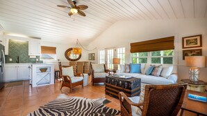 A spacious living area with a sofa, chairs, a zebra rug, and a vintage trunk.