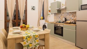 A compact kitchen with a dining area, a washing machine, and a microwave. - Welcome to the Lemora Luxury Home - (Palermo)