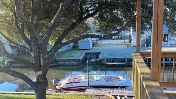 A dock area with boats, a large tree, and a grassy area.