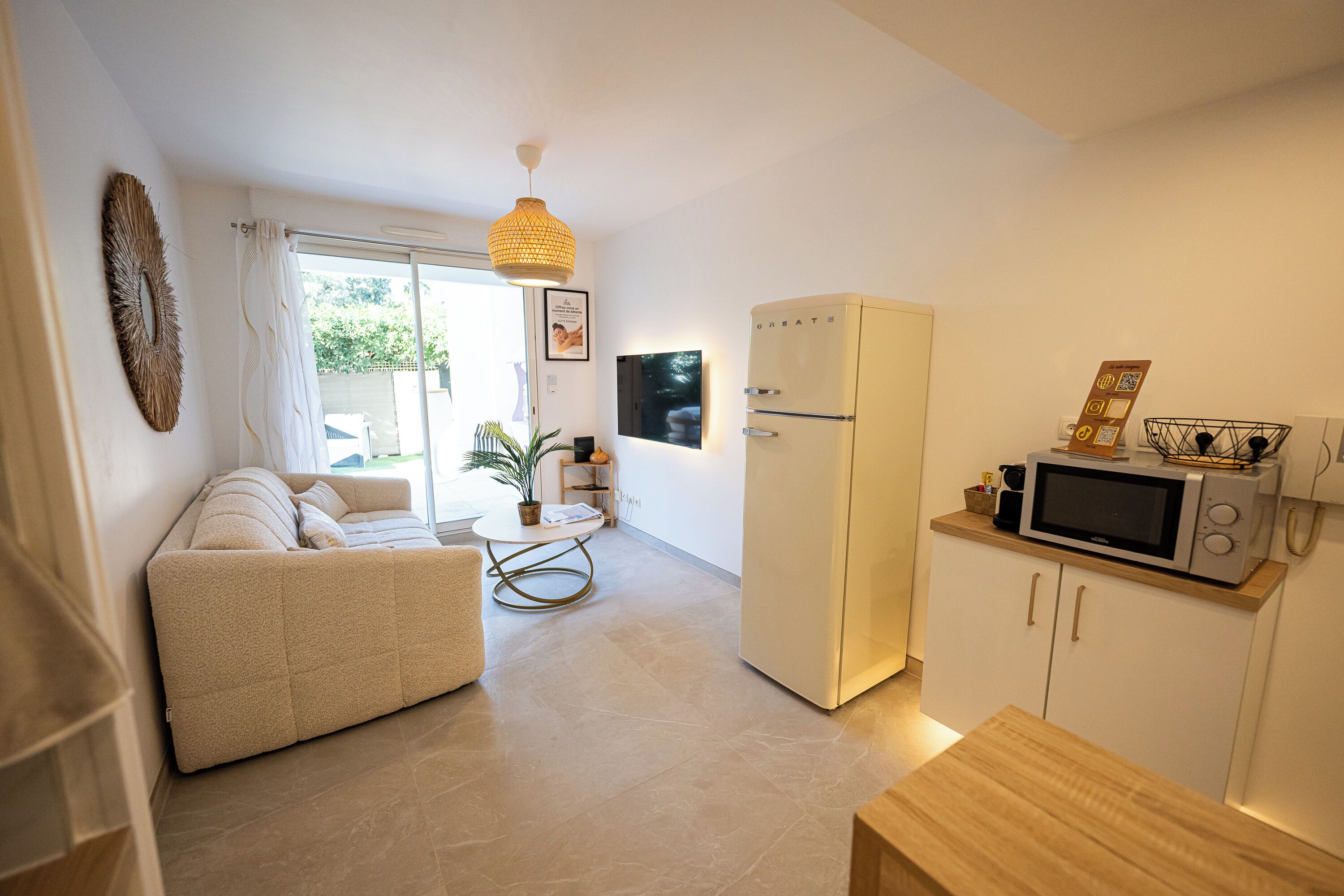 A compact living space with a sofa, a dining table, a refrigerator, and a microwave.