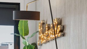 Un salon moderne avec un canapé, une lampe sur pied et un luminaire fixé au mur.