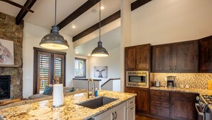 A kitchen with granite countertops, dark wooden cabinets, a built-in microwave, and a gas stove. - Walk to Clubhouse, Mountain View, Summit Sky Ranch Resort Amenities (Silverthorne)