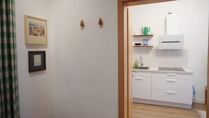 Una cocina con armarios blancos, un lavamanos y un cactus verde en la encimera.