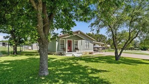 A single-story house with a front porch, a covered patio, and a fenced yard. - Lake Whitney 3BR getaway: family-ready, boat-friendly, Wi-Fi, fire pit (Laguna Park)