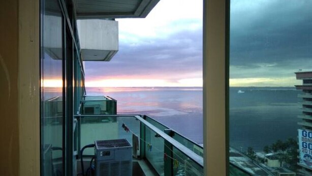 Een balkon met uitzicht op zee en een bewolkte lucht.