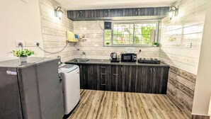A compact kitchen with a built-in microwave, a coffee maker, and a small refrigerator.