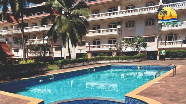 A swimming pool with a tiled edge, surrounded by a brick walkway.