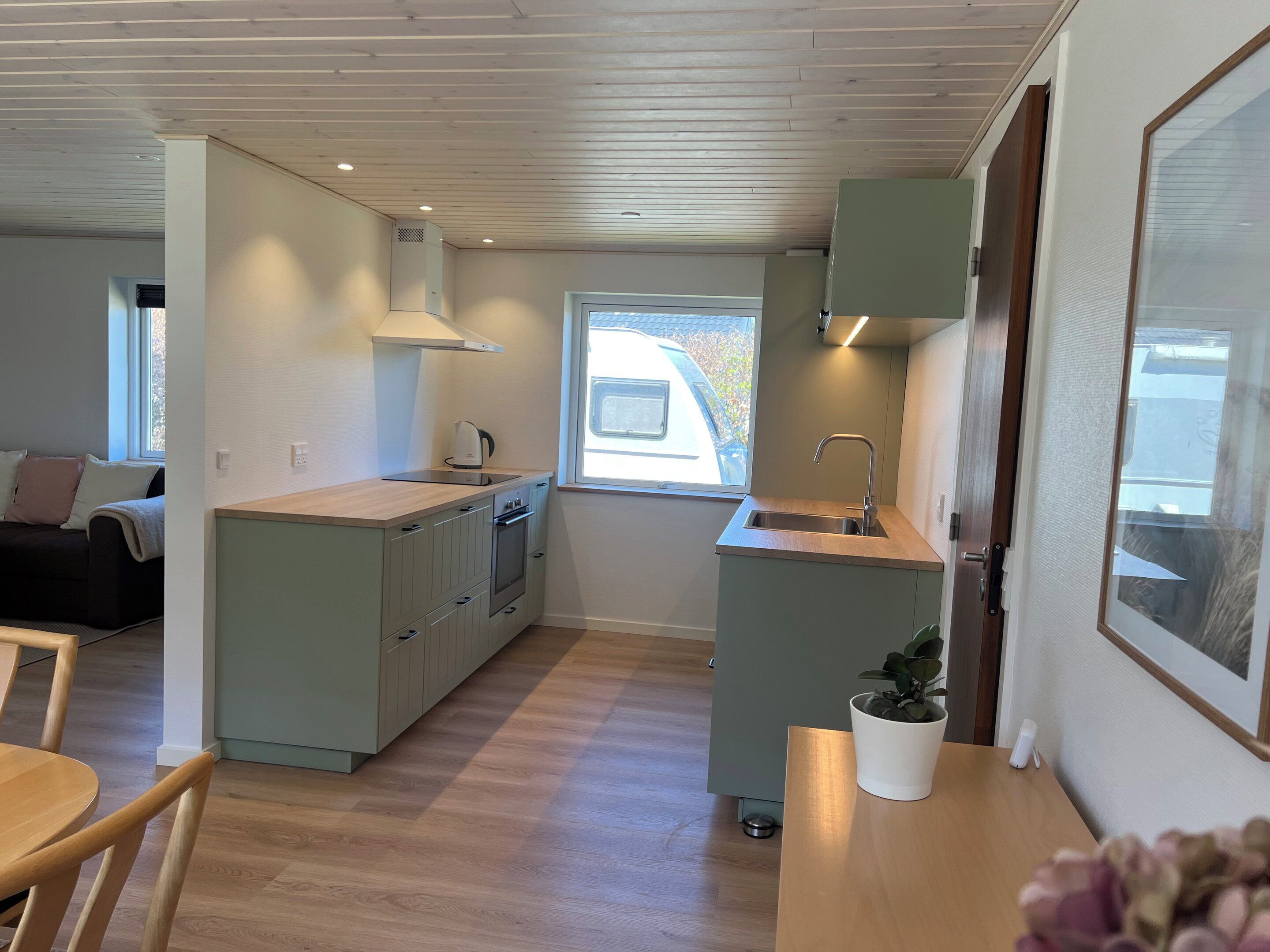 A compact kitchen with a window, a sink, and a stove.