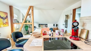 A modern kitchen with a built-in stove, wooden shelves, and a variety of kitchen items. - Zum Storchennest by Interhome (Chemnitz)