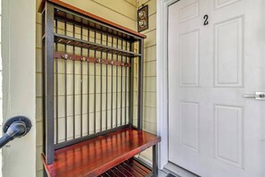 A metal gate with a wooden bench in front of a white door with the number 2. - Cozy Rutland Retreat (Rutland)